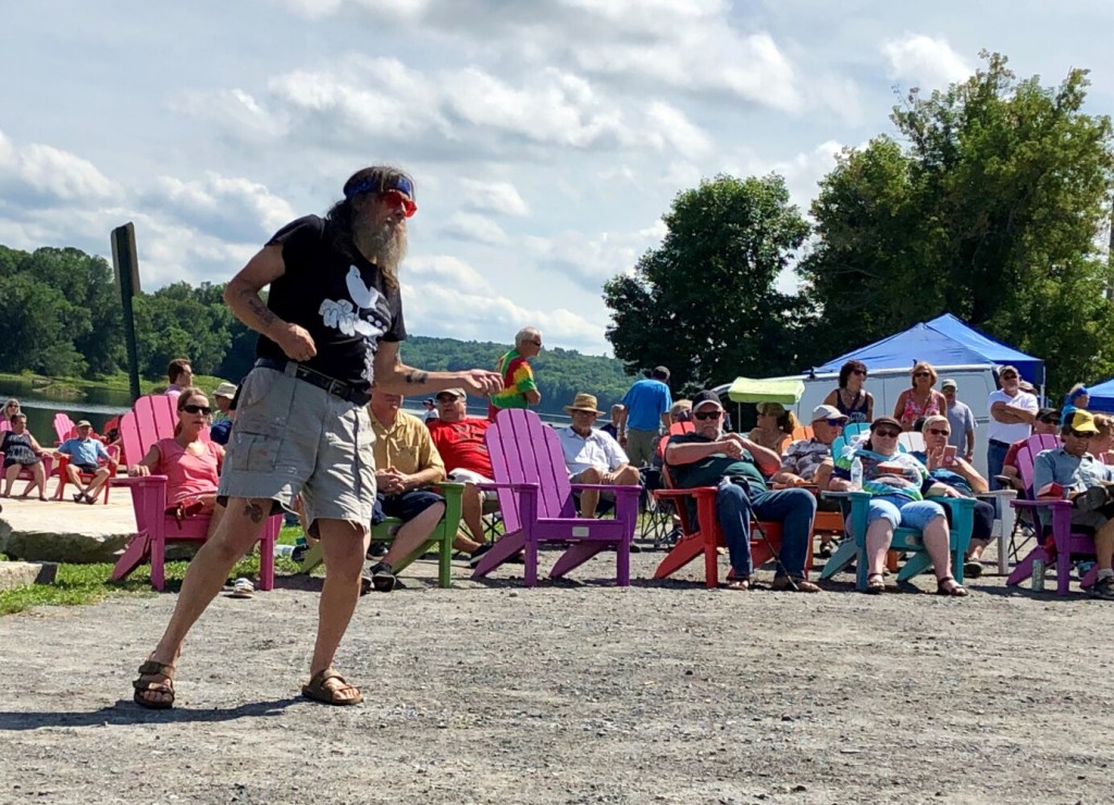 Zoo Cain strums an air guitar Sunday during Hallowell's Woodstock and Art Festival. Cain said he hitchhiked from Boston to the festival 50 years ago.
