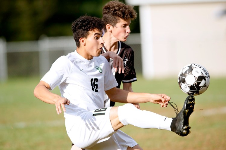 Pat Shaw, left, of Waynflete tries to win the ball against Thomas Suckow of St. Dominic Academy during the first half in Auburn on Tuesday. Waynflete won the game, 3-0.