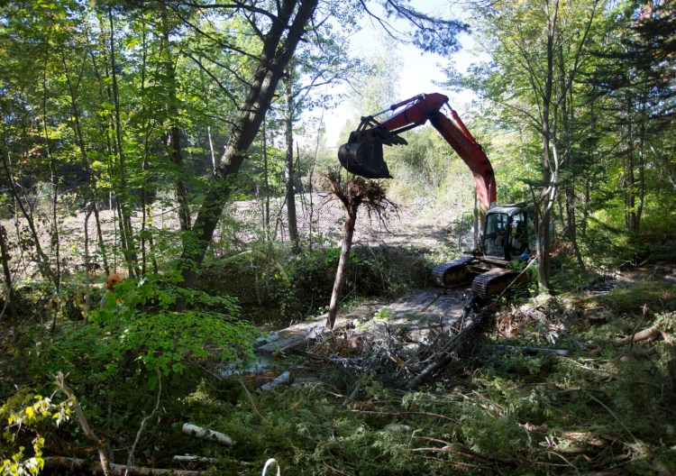 Construction crews install woody debris into the stream channel on Sept. 27 near the Maine Mall in South Portland. 
