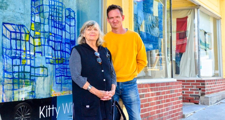Kitty Winslow, left, and Tom Jessen pose for a portrait Sept. 26 in front of their art displayed inside the windows of 347 Water St. in downtown Augusta.