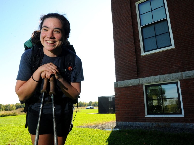 Kaylin Brown, a graduate of the Maine Academy of Natural Sciences, is pictured back on campus in Hinckley on Sunday. Brown, who is seen with her trekking poles and her backpack, returned Saturday after finishing the 2192-mile Appalachian Trail from Georgia to Maine. 