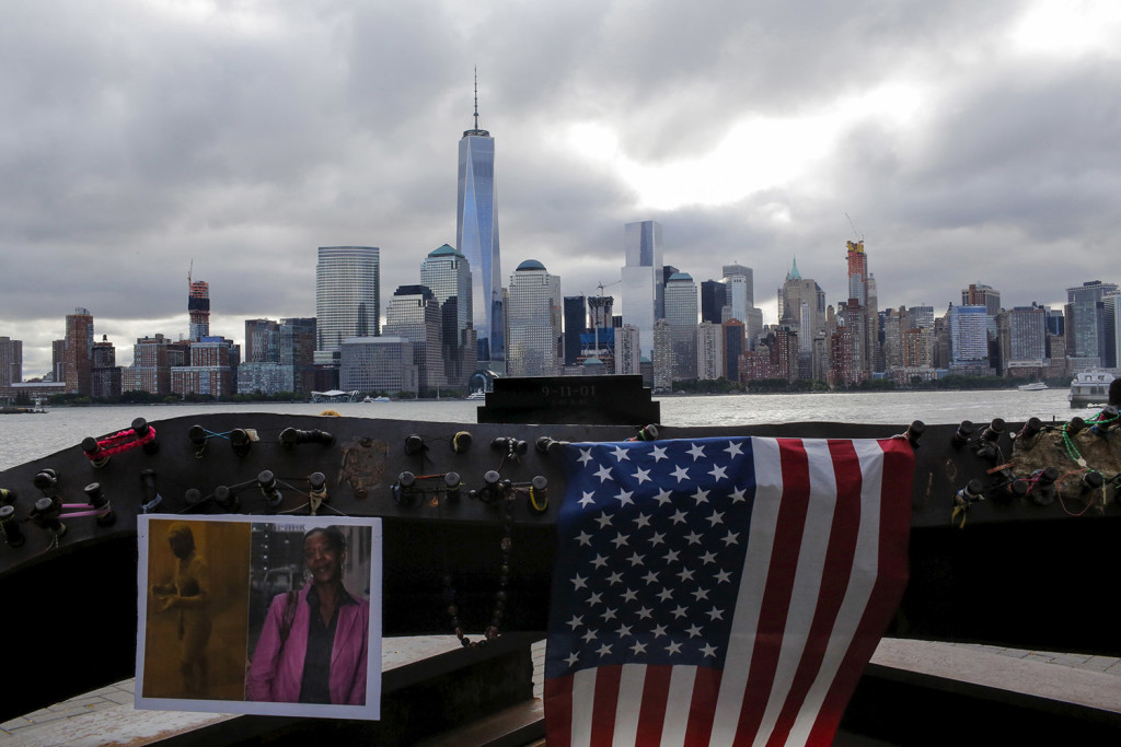 Souvenirs for 9/11 victims are seen in a memorial across from New York's Lower Manhattan and One World Trade Center in Exchange Place, New Jersey September 11, 2015. An overcast Friday greeted relatives who gathered to commemorate nearly 3,000 people killed in the September 11 attacks in New York, Pennsylvania and outside Washington 14 years ago, when airliners hijacked by al Qaeda militants brought death, mayhem and destruction. REUTERS/Eduardo Munoz - RTSNF1
