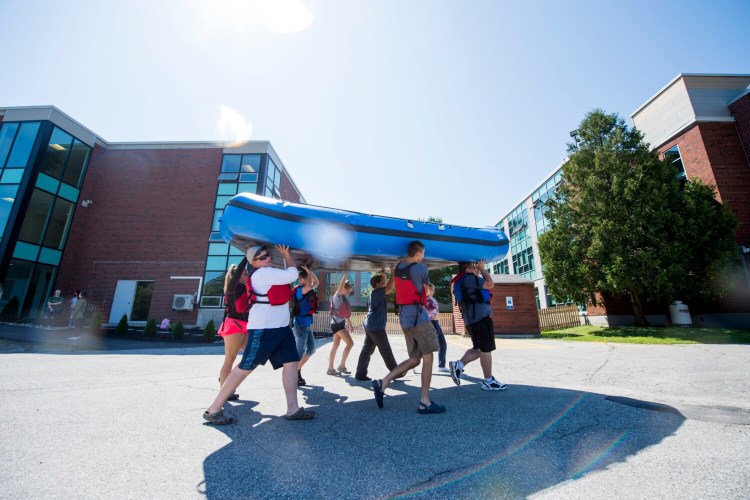 Students in the new Outdoor Leadership and Natural Resource Management program at Mid Maine Technical Center at Waterville Senior High School haul their raft back to school after floating the Messalonskee Stream on Aug. 30. 