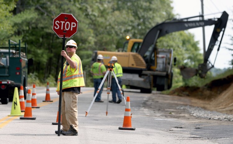 Maine Department of Transportation worker Richard Roscoe controls traffic at a job site in North Yarmouth on Sept. 6. A shortage of workers in government, both state and local, is widespread in Maine. Roscoe has worked for the transportation department for two years.