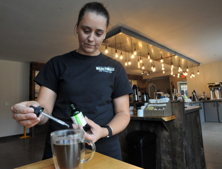 Jessica Thurlow, store manager at The Warehouse, uses an eye dropper to add a dose of CBD oil to a medium roast coffee at the store located at 826 Kennedy Memorial Drive in Waterville on Sept. 6, 2019. 