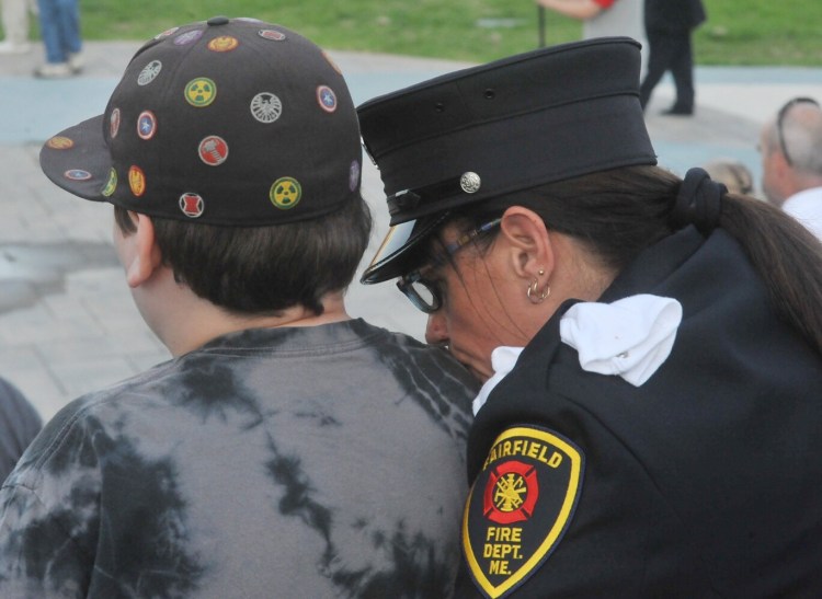 Stephanie Aucoin, of the Fairfield Fire Department, shares a quiet moment with her grandson Damian Colby, 11, during a ceremony commemorating the 18th anniversary of the Sept. 11, 2001, terrorist attacks. Wednesday's ceremony, which drew about 50 people, was held along the RiverWalk in Waterville.