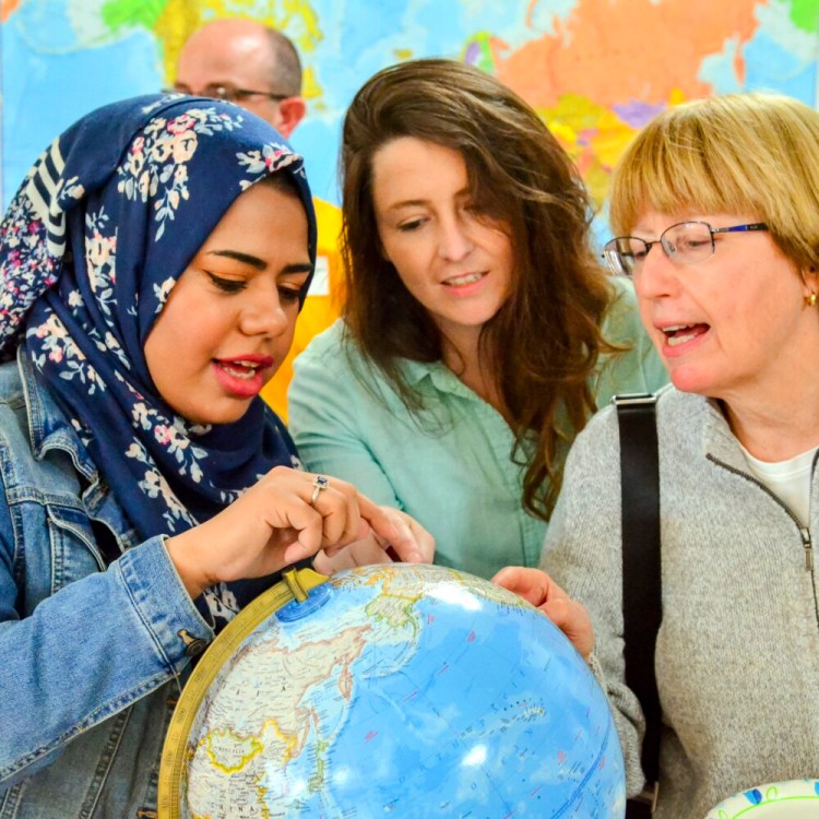 Hadeel Alsaleh, left, Melissa Taylor and Deb Sewall chat around a globe during the open house reception Sept. 18 at the new Augusta Multicultural Center at 70 State St., next to Lithgow Library, in Augusta.