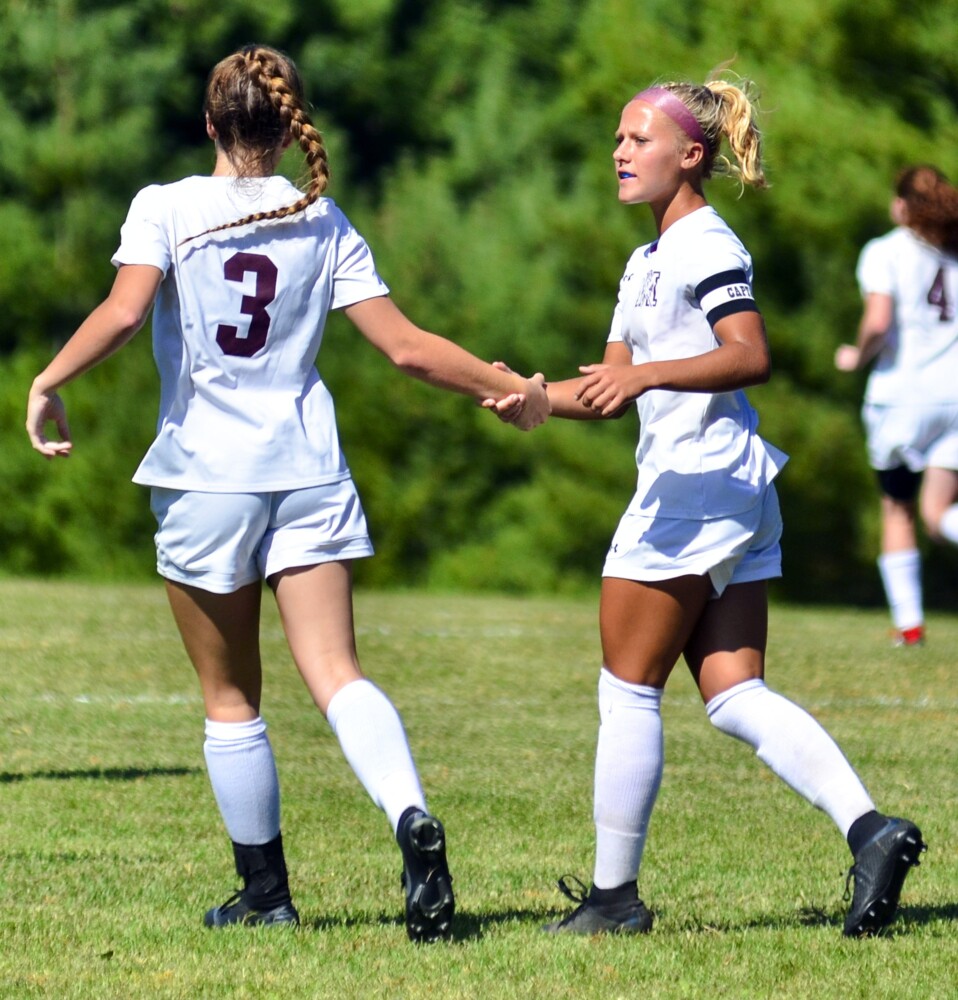 Monmouth Academy's Madisyn Smith, left, congratulates Audrey Fletcher after Fletcher scored a goal against Hall-Dale on Saturday in Farmingdale.
