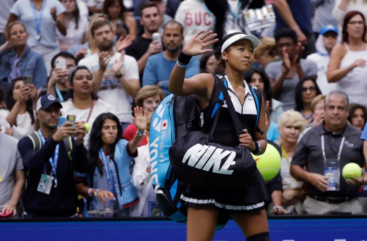 Naomi Osaka waves to the crowd after a 7-5, 6-4 loss to Belinda Bencic in the fourth round of the U.S. Open on Monday in New York. Osaka was the No. 1 seed and the defending champion.