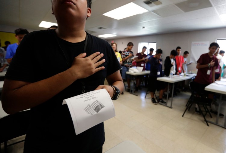 Immigrants say the Pledge of Allegiance in a writing class at a U.S. government holding center for migrant children in Carrizo Springs, Texas, in July. 