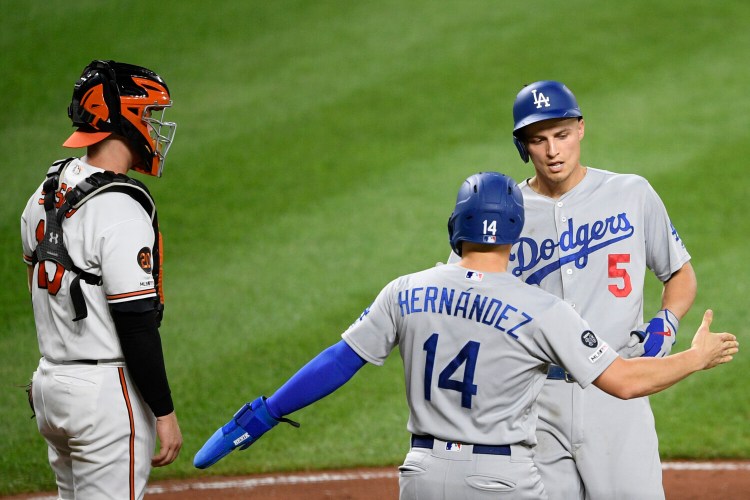 Corey Seager, right, celebrates his two-run home run with Enrique Hernandez during the third inning of the Dodgers' 7-3 win over the Orioles in Baltimore. The Dodgers clinched their seventh straight NL West title with the win.