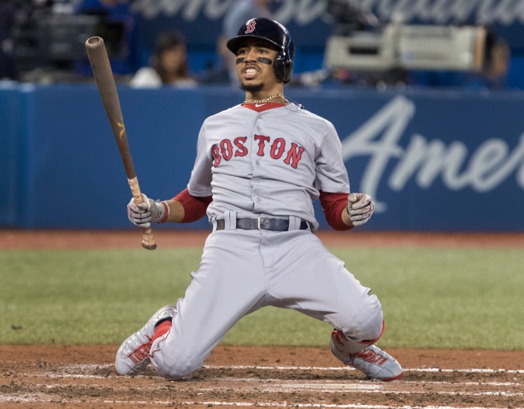 Boston Mookie Betts drops to his knees after avoiding being hit by a pitch Tuesday night against the Blue Jays in Toronto. Betts hit a leadoff home run, but Boston lost, 4-3.
