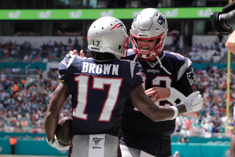 Patriots quarterback Tom Brady, right, and wide receiver Antonio Brown celebrate after Brown caught a 20-yard touchdown pass in the second quarter of the Patriots' win Sunday in Miami.