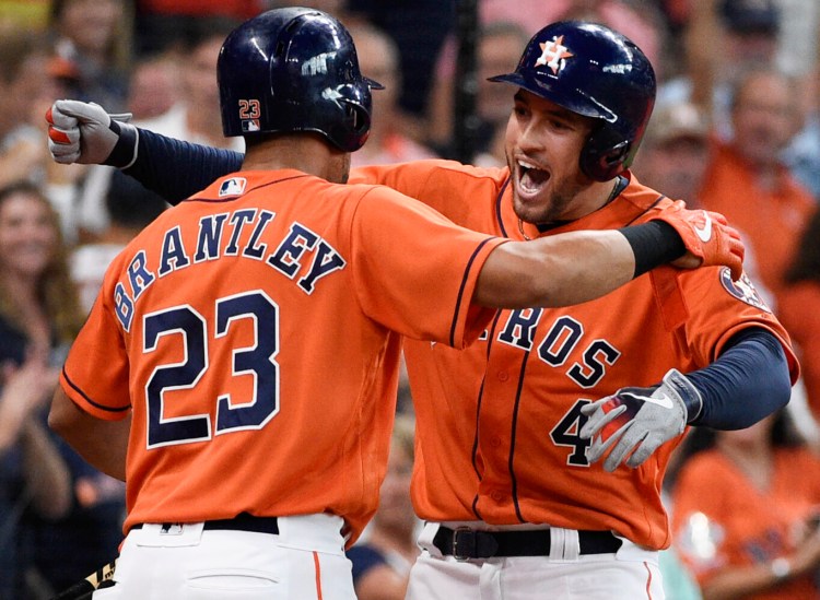 Houston’s George Springer, right, celebrates one of his three homers with Michael Brantley during the Astros’ 13-5 win that clinched the AL Central, in Houston.