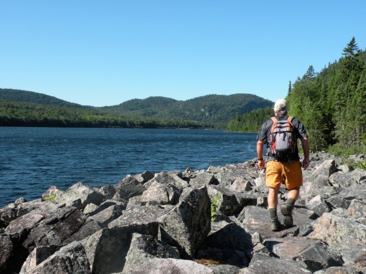 Crossing a talus field along Deboullie Pond on the Deboullie Loop Trail. The remote Deboullie Public Lands in Aroostock Country encompasses more than 20,000 acres of heavily forested country, 17 pristine ponds and a cluster of low but rugged peaks.