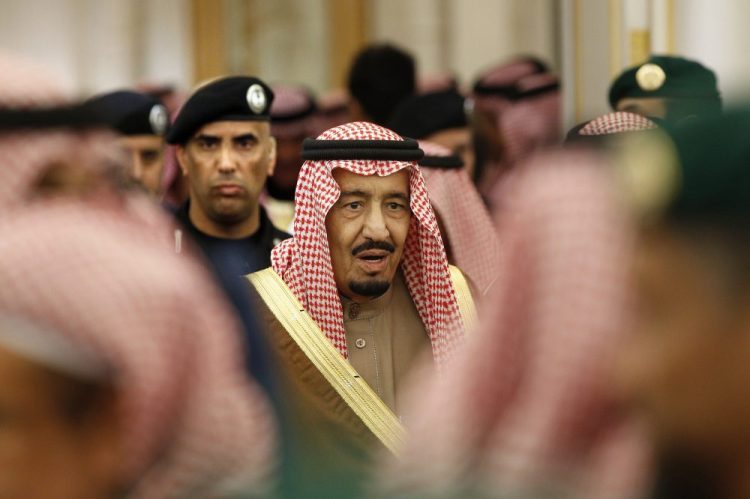 Saudi Arabia's King Salman is guarded by his bodyguard Maj. Gen. Abdulaziz al-Fagham, background, as he attends a ceremony at the Diwan royal palace in Riyadh, Saudi Arabia. Al-Fagham, a prominent bodyguard to King Salman was shot and killed in the Red Sea city of Jiddah, in what authorities described as a personal dispute, state TV reported Sunday.