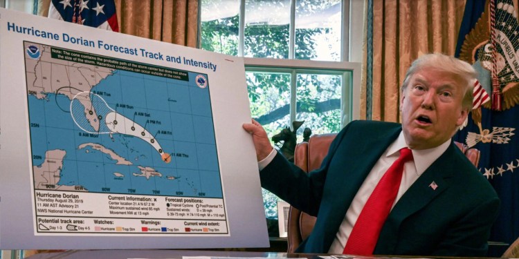 Trump displays a modified National Hurricane Center "cone of uncertainty" forecast  graphic which was  altered with a marker to indicate a risk that the storm would move into Alabama from Florida.