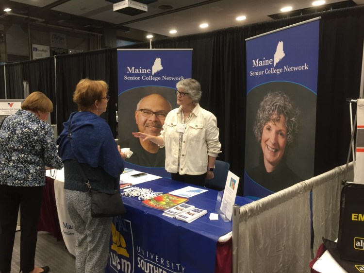 Anne Cardale, program director of the Maine Senior College Network, chats with people attending the Maine Wisdom Summit at the Augusta Civic Center on Tuesday. It's the sixth annual conference addressing the challenges of aging that are facing the oldest state in the nation.