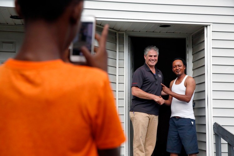 Michel Butera poses with Portland Mayor Ethan Strimling as Butera's 11-year-old son takes their photo. The men met while Strimling campaigned door-to-door last month at the Munjoy South housing development.