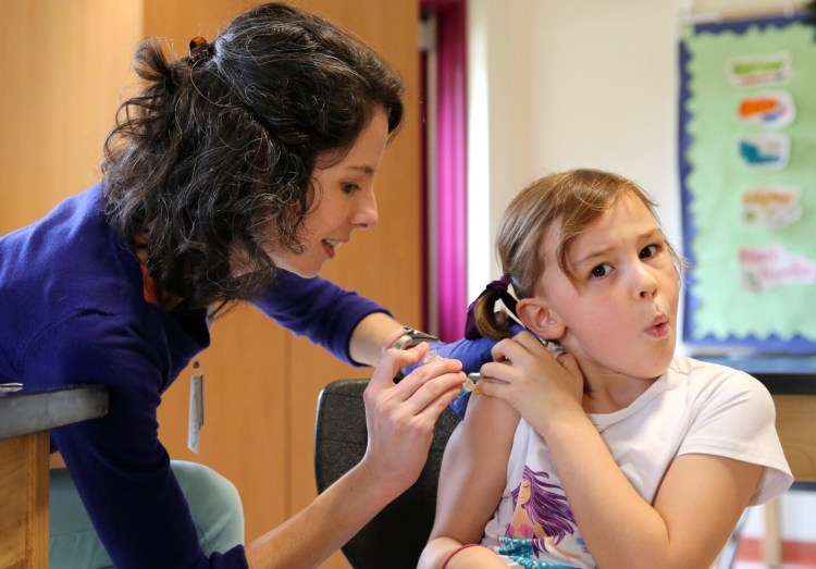 Amanda Hogan, a registered nurse at Northern Light Home Care, administers an influenza vaccine to first-grader Lula Bennett on Thursday at Brown Elementary School in South Portland. 