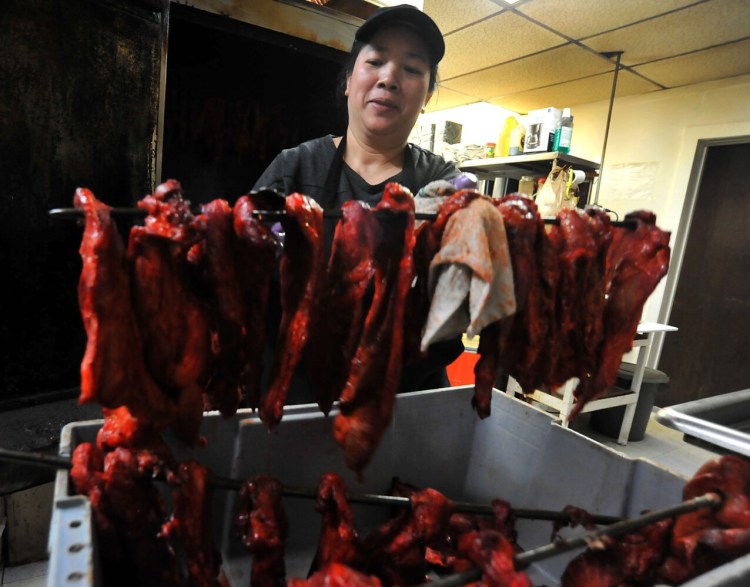 Tina Qing of Cheung Lee Express Chinese Restaurant prepares barbecue pork ribs Thursday while working in the kitchen of the Fairfield restaurant.