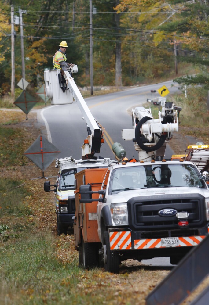 Central Maine Power crews work to restore power along School Street in Alfred following a nor'easter that blew through the region in October 2019. The state Public Utilities Commission is launching an investigation into whether management decisions by CMP's parent company Avangrid have negatively affected customers in Maine.