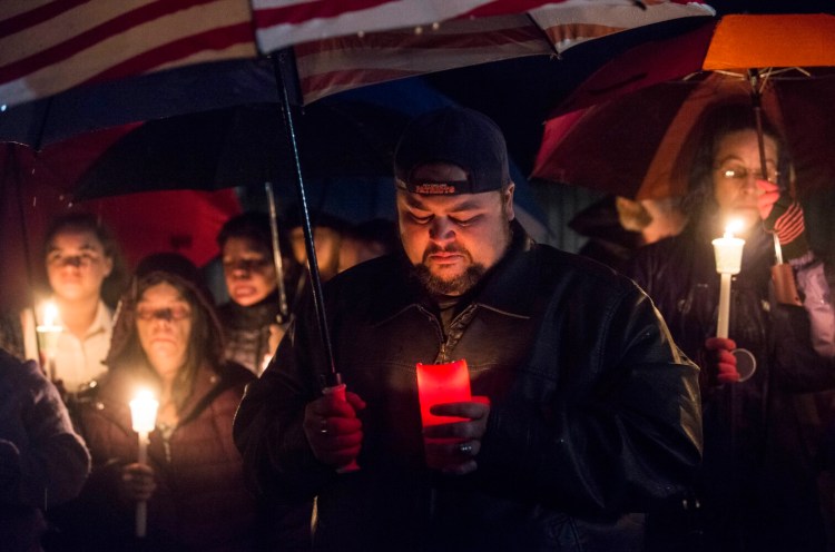Dustin Thibedeau, a friend and neighbor of Melissa Sousa, cries during a candlelight vigil Sunday night in Waterville. 