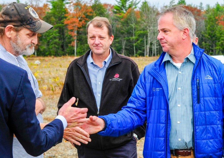 Bill Lovely, left, shakes hands with Shawn Lyden, of Maine Capital Group, after Lyden's high bid won the auction Oct. 30 in Gardiner.