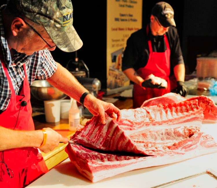 Leon Emery, left, cuts off ribs as Scott Gooding vacuum packs roasts in plastic bags during a hog butchery and sausage making demonstration Oct. 8, 2016, in Johnson Hall. The event was part of the annual Swine & Stein celebration in downtown Gardiner.
