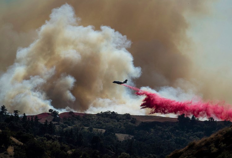 A tanker drops retardant Oct. 11 on the Saddleridge fire burning in Newhall, Calif.