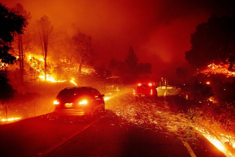 Embers fly across a roadway as the Kincade Fire burns through the Jimtown community of Sonoma County, Calif., on Thursday.