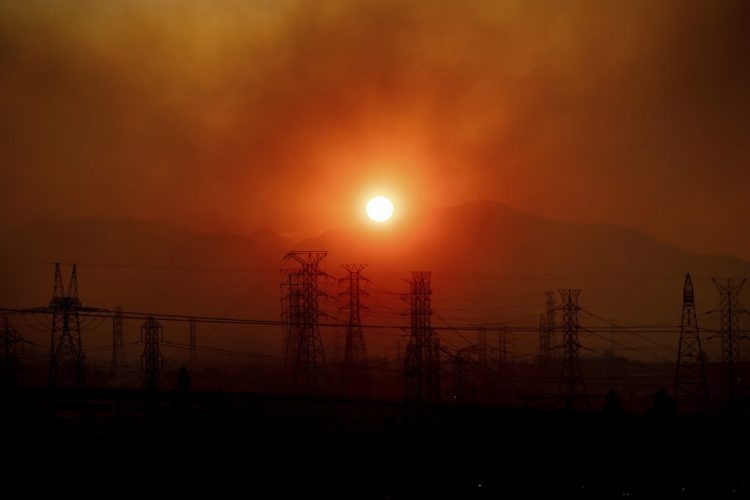 Smoke from the Saddleridge Fire hangs above power lines as the sun rises in Newhall, Calif., on Friday. 