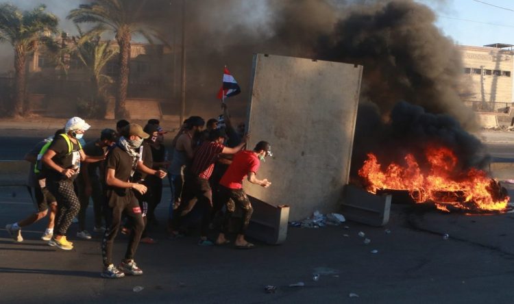 Anti-government protesters set fires and close a street during a demonstration in Baghdad, Iraq, Friday. Security forces opened fire at hundreds of anti-government demonstrators in central Baghdad, killing some protesters and injuring dozens, hours after Iraq's top Shiite cleric warned both sides to end four days of violence "before it's too late."