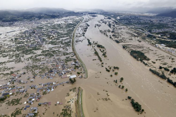 Residential areas are submerged in muddy water Sunday after an embankment of the Chikuma River broke because of Typhoon Hagibis, in Nagano, central Japan. 