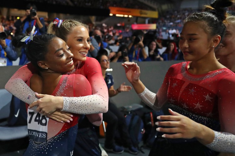 Simone Biles, left, gets hugs from her teammates after her floor exercise, clinching the gold medal in the women's team final at the Gymnastics World Championships in Stuttgart, Germany on  Tuesday.
Matthias Schrader/Associated Press