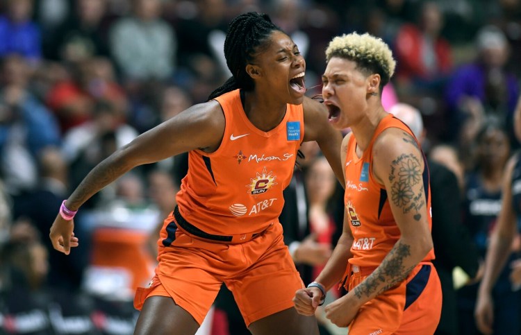 Connecticut Sun's Bria Holmes, left, and Natisha Hiedeman celebrate a basket against the Washington Mystics during  Game 4 of the WNBA finals Tuesday in Uncasville, Conn.