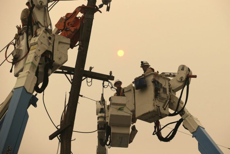 Pacific Gas & Electric crews work to restore power lines in Paradise, Calif., on Nov. 9, 2018. Two years to the day after some of the deadliest wildfires tore through Northern California wine country, two of the state's largest utilities were poised Tuesday to shut off power to more than 700,000 customers in 34 counties, in what would be the largest preventive shut-off to date as utilities try to head off wildfires caused by faulty power lines. 