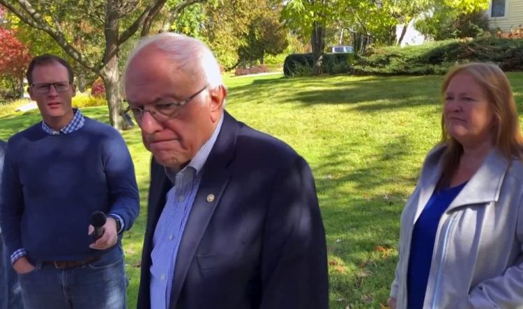 Democratic presidential candidate Sen. Bernie Sanders, I-Vt., speaks with reporters outside his home on Tuesday in Burlington, Vt. Sanders says he was "dumb" not to have listened to the symptoms he was experiencing before he suffered a heart attack last week. 