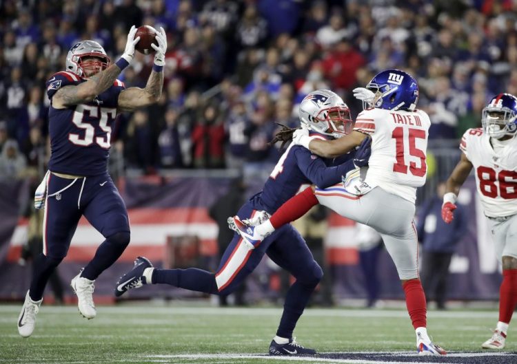 New England Patriots defensive end John Simon (55) intercepts a pass intended for New York Giants wide receiver Golden Tate (15) in the first half of Thursday's game.