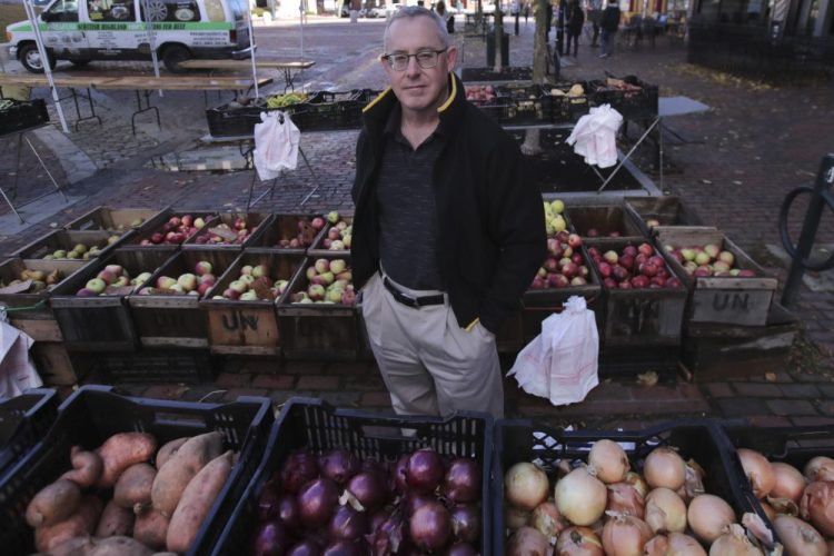 John Gold, self-employed graphics designer, stands at a farmer's market outside his office in Portland, Maine, on Wednesday. Gold has been covered by the Affordable Care Act since it started. The 2020 sign-up season for the Affordable Care Act is getting underway with premiums down slightly in many states and more health plan choices for consumers. 