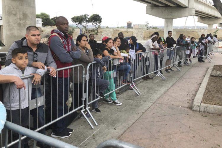 Asylum seekers in Tijuana, Mexico, listen to names being called from a waiting list to claim asylum at a border crossing in San Diego on Sept. 26. The number of migrants currently held in CBP custody is approximately 4,000, down from 19,000 in early June.