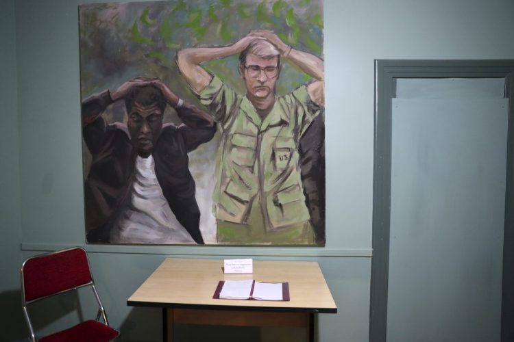A painting of one of the images of the takeover of U.S. Embassy in Tehran in 1979, which shows U.S. Marine Sgt. Ladell Maples of Earle, Ark., left, and Cpl. Steve Kirtley of Little Rock, Ark., with their hands above their heads, adorns a wall of the embassy, now partly a museum, in Tehran, Iran.  Images like those of surrendering American troops carry a strong resonance for hard-liners in Iran.