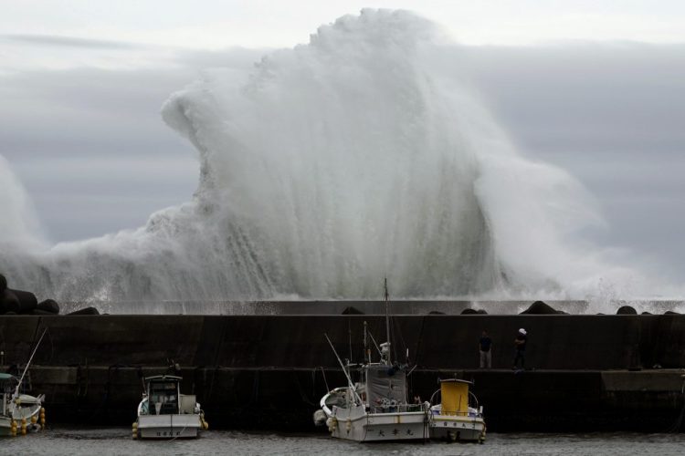 Surging waves hit against the breakwater behind fishing boats as Typhoon Hagibis approaches at a port in town of Kiho, Mie Prefecture, Japan. 