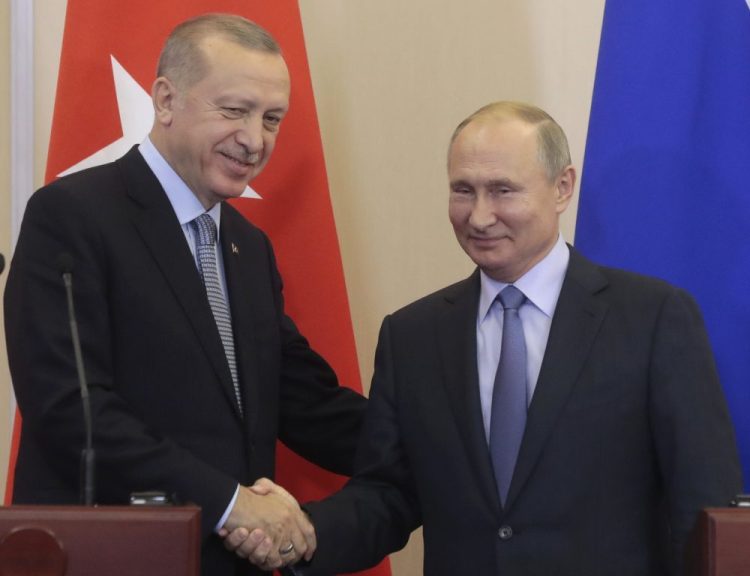 Russian President Vladimir Putin, right, and Turkish President Recep Tayyip Erdogan shake hands after their joint news conference following their talks in the Bocharov Ruchei residence in the Black Sea resort of Sochi, Russia, on Tuesday. Erdogan says Turkey and Russia have reached a deal in which Syrian Kurdish fighters will move 18 miles away from a border area in northeast Syria within 150 hours. 