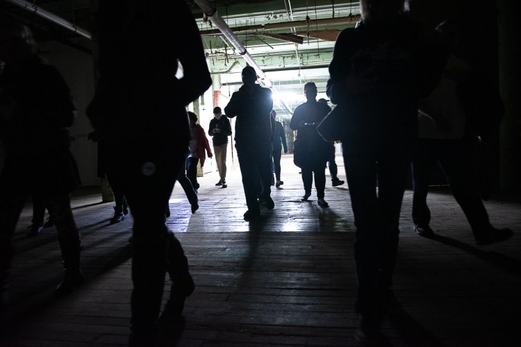 Visitors walk through the basement of the Bates Mills on Saturday evening with the Maine Ghost Hunters, who have been invited to investigate possible paranormal activity.