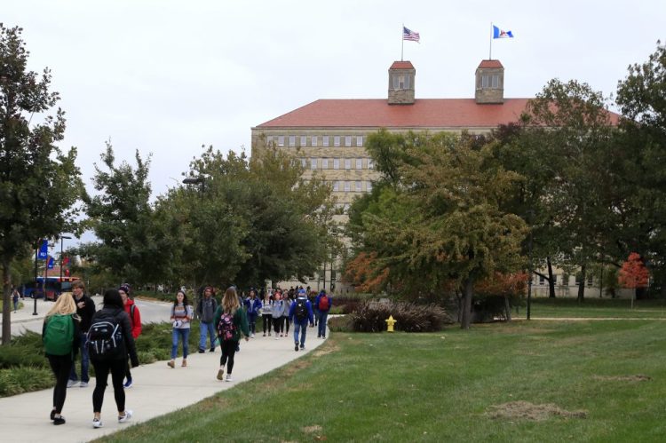In this Oct. 24, 2019, file photo students walks in front of Fraser Hall on the University of Kansas campus in Lawrence, Kan. Americans collectively owe nearly $1.5 trillion in student loans, more than twice the total a decade ago. 