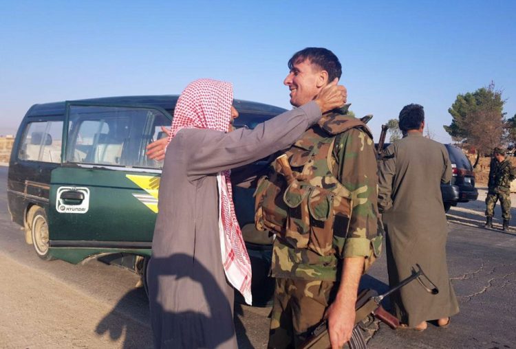 In this photo released by the Syrian official news agency SANA, a resident hugs a Syrian soldier shortly after Syrian troops entered the northern town of Tal Tamr on Monday. The move toward Tal Tamr came a day after Syria's Kurds said Syrian government forces agreed to help them fend off Turkey's invasion – a major shift in alliances that came after President Trump ordered all U.S. troops withdrawn from the northern border area amid the rapidly deepening chaos. 