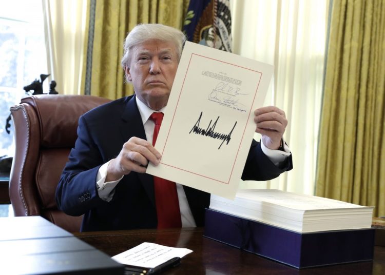 President Trump displays the $1.5 trillion tax overhaul package he signed in the Oval Office of the White House in Washington. Trump is now three for three. Each year of his presidency, he has issued more executive orders than did former President Barack Obama during the same time-span.