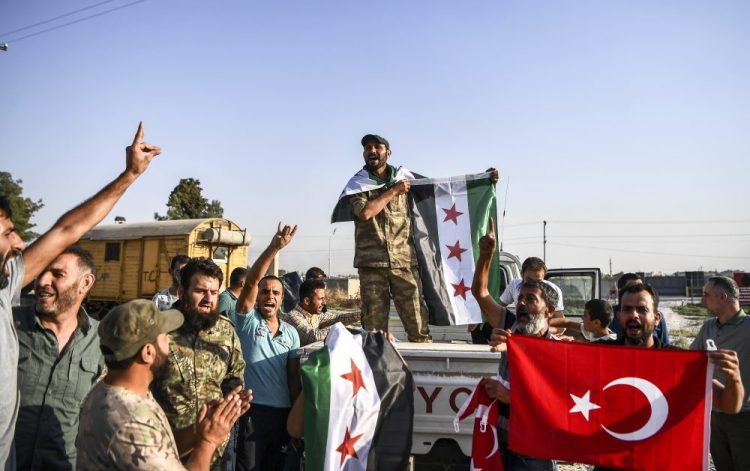 Turkish-backed Syrian opposition fighters celebrate in Akcakale, in Sanliurfa province advance, after entering over the border from Tal Abyad, Syria on Sunday. 