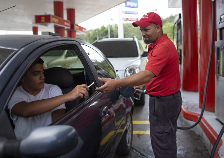 Gas station attendant Leowaldo Sanchez takes a cigarette as payment from a motorist as he fills the tank in San Antonio de los Altos, Venezuela, on Oct. 8. This barter system, while perhaps the envy of cash-strapped drivers outside the country, is just another symptom of bedlam in Venezuela where a full tank these days costs a tiny fraction of a U.S. penny. 